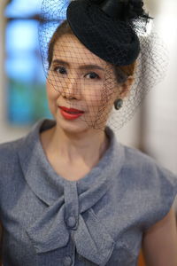 Portrait of woman wearing veiled hat 