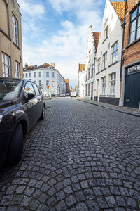 Surface level of street amidst buildings in city against sky