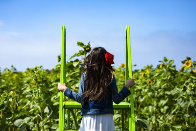 Rear view of woman standing by plants