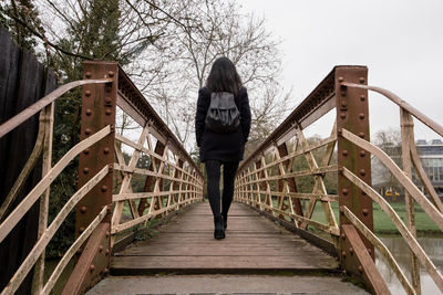 Rear view of woman standing on footbridge