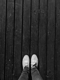 Low section of person standing on wooden floor