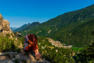 Woman looking at mountain against sky