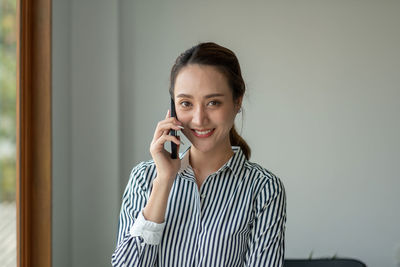 Portrait of smiling businesswoman talking on smart phone