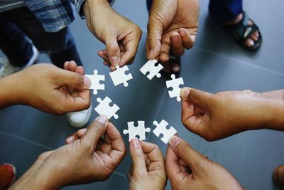 High angle view of people holding puzzles