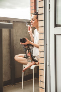 Girl house balcony with her doll during lockdown period due to covid-19 epidemic.