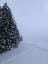 Snow covered landscape against clear sky