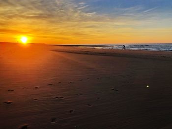 Scenic view of beach against sky during sunset