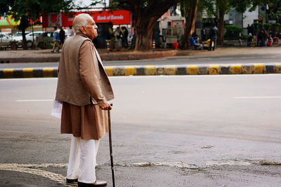 Woman walking on footpath in city