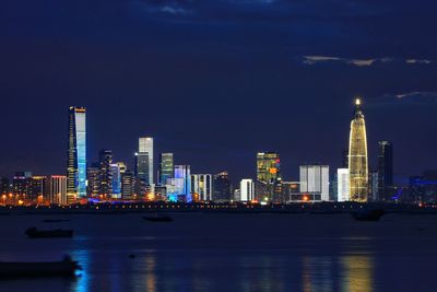 Illuminated buildings in city against sky at night