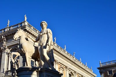 Low angle view of statue against blue sky