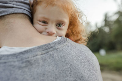 Father carrying redheaded daughter with green eyes