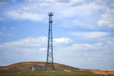 A tall power tower on the hillside