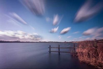 Scenic view of lake against cloudy sky