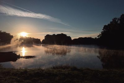 Scenic view of lake against sky at sunset