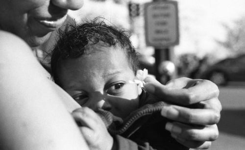 Baby looking at flower held by mother