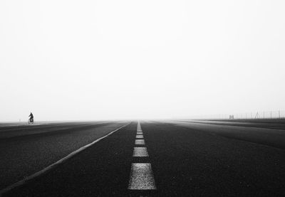 Empty road against cloudy sky