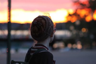 Rear view of boy against sky during sunset