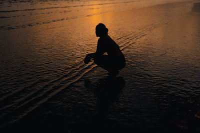 Silhouette woman standing in sea