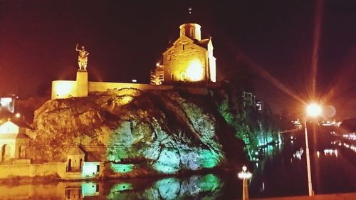 Low angle view of illuminated building against sky at night