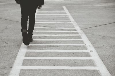 Low section of people man waking on zebra crossing