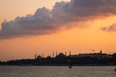 Silhouette sailboats in sea against sky during sunset