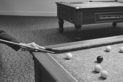 Cropped man aiming ball at pool table