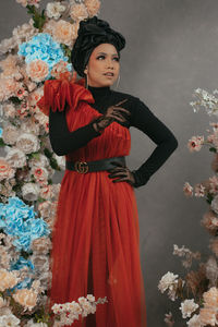 Portrait of young woman standing against wall