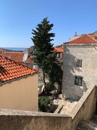 Houses and trees against clear blue sky