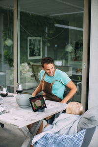 Young man using mobile phone while sitting on table