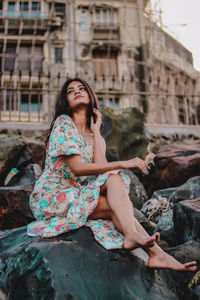 Young woman sitting on rock