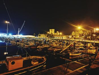 Illuminated harbor against sky at night