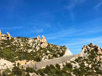 Low angle view of mountain against blue sky