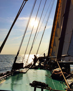 People sailing on sea against sky