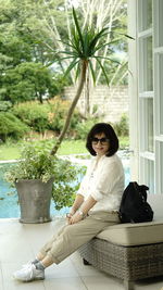 Woman sitting on potted plant