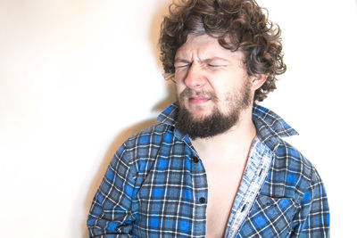 Light falling on man with eyes closed by white wall