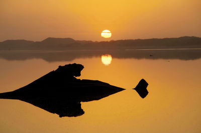 Silhouette landscape against sky at sunset