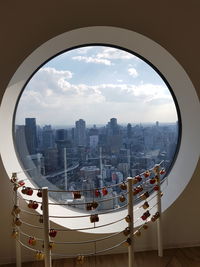 Cityscape against sky seen through glass window