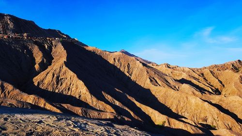 Scenic view of mountains against blue sky