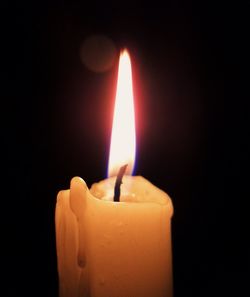 Close-up of burning candle in darkroom