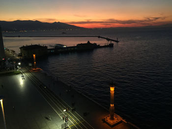 High angle view of illuminated sea against sky during sunset