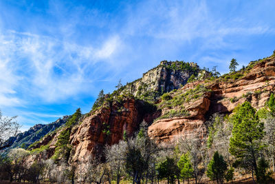 Low angle view of rocky mountain against blue sky