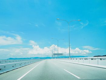 Street lights on highway against sky