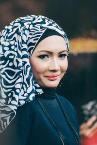 Close-up portrait of smiling young woman wearing hijab
