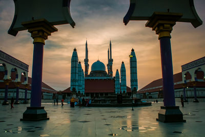 View of mosque in city against sky during sunset