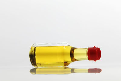 Close-up of olive oil in bottle against white background