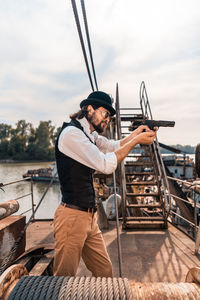 Man holding boat against sky