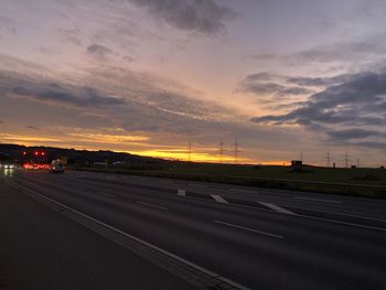 Road against sky during sunset in city