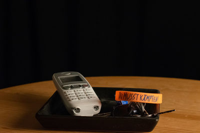 Close-up of telephone on table against black background