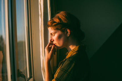 Young woman standing by window