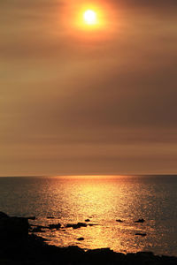 Scenic view of sea against orange sky